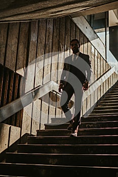 Businessman with sunglasses walking down the stairs