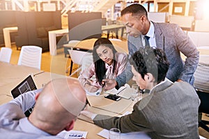 Businessman supervising his employees as they brainstorm and work together