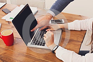 Businessman supervising secretary work on laptop, closeup of hands, unrecognizable