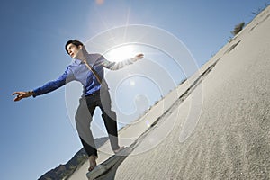 Businessman Surfing Downhill On Briefcase