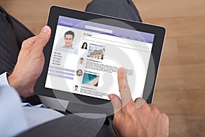 Businessman surfing social networking site on digital tablet