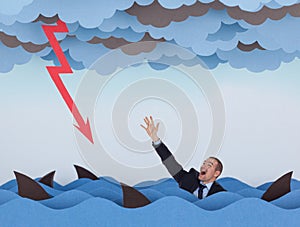 Businessman surrounded by sharks in stormy sea