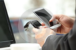 Businessman synchronizing a smart watch and phone