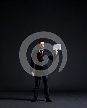 Businessman with a tablet gadget. Black background with copyspace. Business and office technology concept.