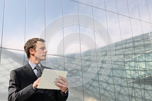 Businessman with tablet that looks far into the sky