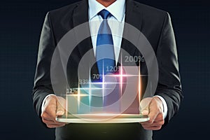 Businessman with tablet pc showing glowing graph