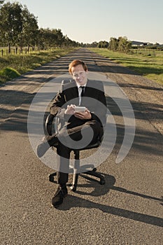 Businessman with tablet on road