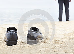 Businessman take off his shoes on the beach