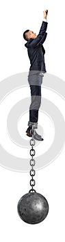 A businessman take a superhero jump in the air with an iron ball still attached to his ankle with a solid chain.