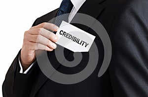 Businessman takes out a business card from his pocket with the word credibility. Trust in business or financial credibility