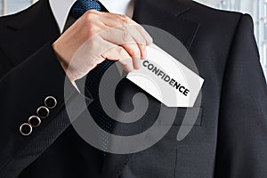 Businessman takes out a business card with the word confidence