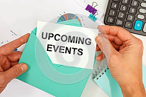 The businessman takes out a card from the envelope with the text UPCOMING EVENTS