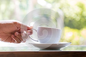 Businessman taking coffee cup for drinking in coffee cafe