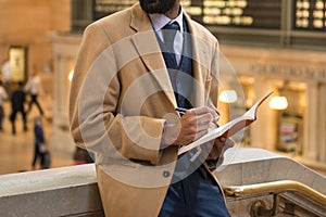 Businessman taking note using pen and notepad wearing cashmere jacket and business suit