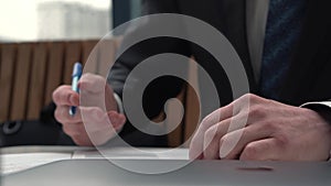 Businessman taking notes or signing contract, pen and document, man in formal jacket. Close up hand