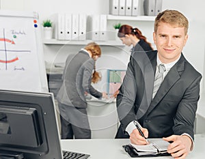 Businessman taking notes and smiles