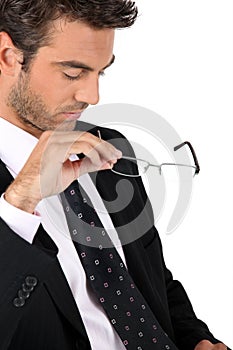 Businessman taking off his glasses