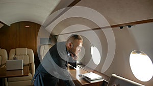 Businessman talk by phone indoor of private jet cabin