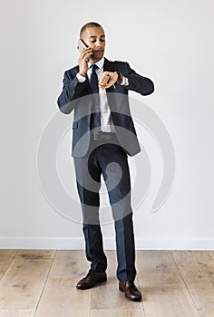 Businessman talking on call checking time fro wrist watch