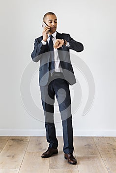Businessman talking on call checking time fro wrist watch photo