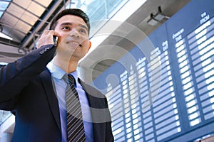 Businessman talking on cell phone inside the airport terminal