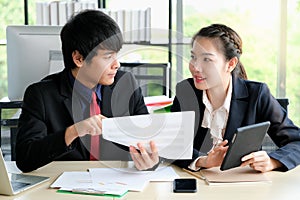 Businessman is talking with his collegue and point to paper chart in the modern office photo