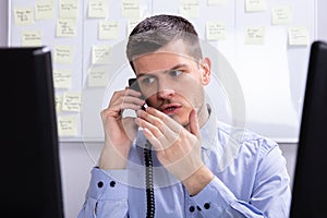 Businessman Talking On Landline Phone photo
