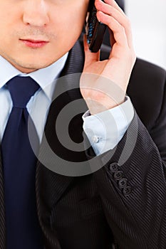 Businessman talking on mobile phone. Close-up.