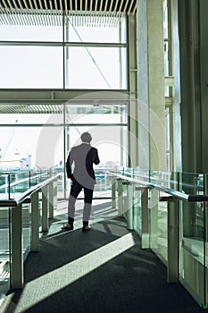 Businessman talking on mobile phone in corridor at modern office building