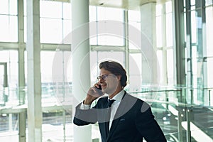 Businessman talking on mobile phone in a modern office building