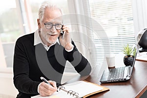 Businessman talking on mobile phone to make an appointment photo
