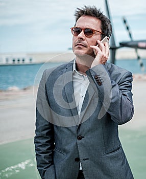 Businessman talking over the phone near private helicopter