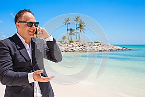 Businessman talking on phone at the beach