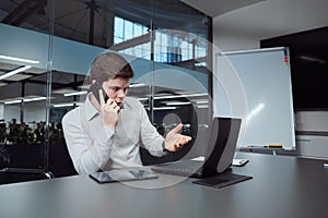 Businessman talking on phone and checking financial charts