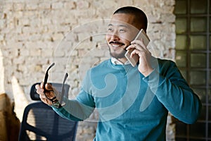 Businessman talking phone with client at coworking office