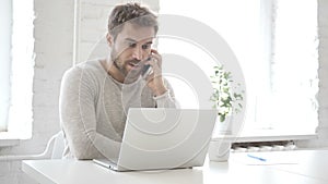 Businessman Talking on Phone, Discussing Work