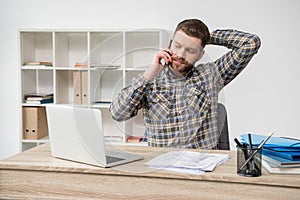 Businessman talking on phone at modern office