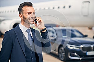 Businessman talking on the phone near an airplane