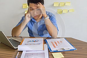 Businessman talking on phone with sticky notes on wall