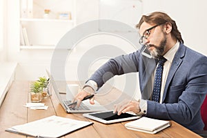 Businessman talking on phone and using tablet photo