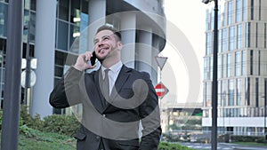 Businessman Talking on Phone while Walking to Office