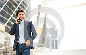 The businessman talking with smart phone on his way. Feeling happy and relaxing, Casual young businessman wearing suit jacket