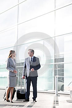 Businessman talking to businesswoman in airport departure area