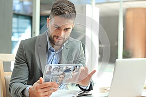 Businessman talking to his colleagues in video conference. Business team working from office using transparent tablet