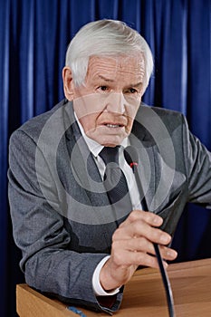 Businessman talking to journalists at conference