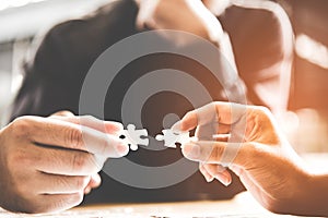 Businessman team work holding two jigsaw connecting couple puzzle piece for matching to goals target, success and start up new pro