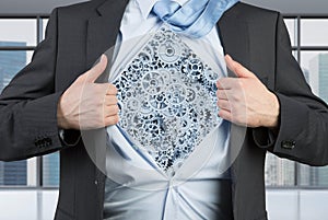 Businessman tearing his shirt with gray cogs