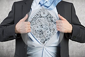 Businessman tearing his shirt with gray gears