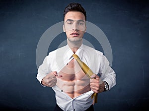 Businessman tearing off shirt and showing mucular body