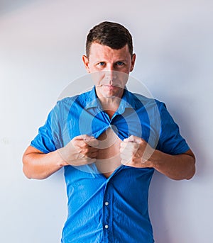 Businessman tearing off his shirt and showing mucular body concept on background